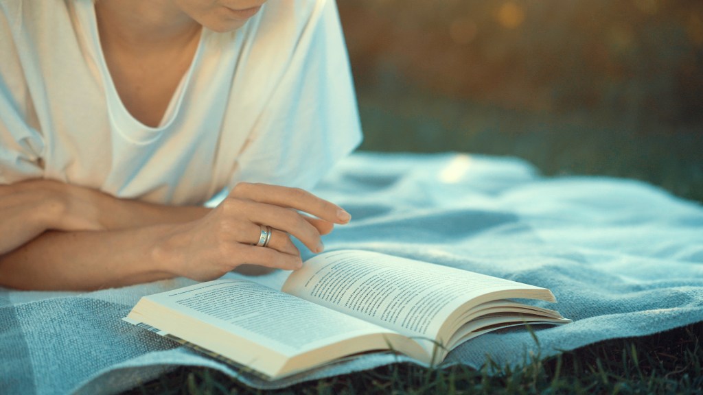 Young woman reading a book in the park